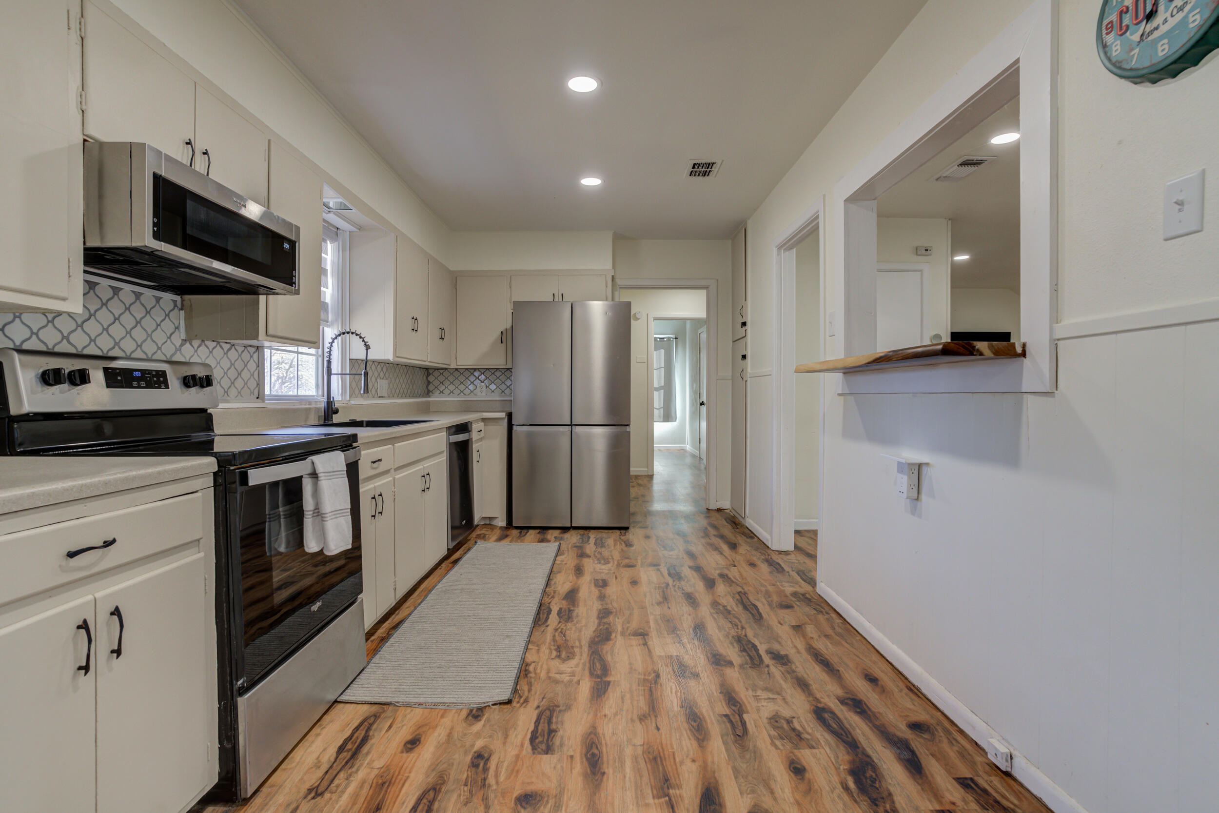 4609 Elgin Avenue Lubbock, TX 79413 - Photo 11 of 46 a kitchen with stainless steel appliances a refrigerator sink and stove
