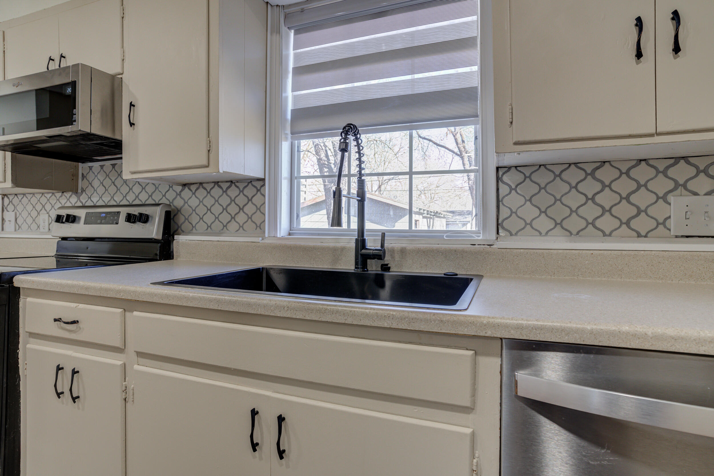 4609 Elgin Avenue Lubbock, TX 79413 - Photo 14 of 46 a kitchen with white cabinets and a sink