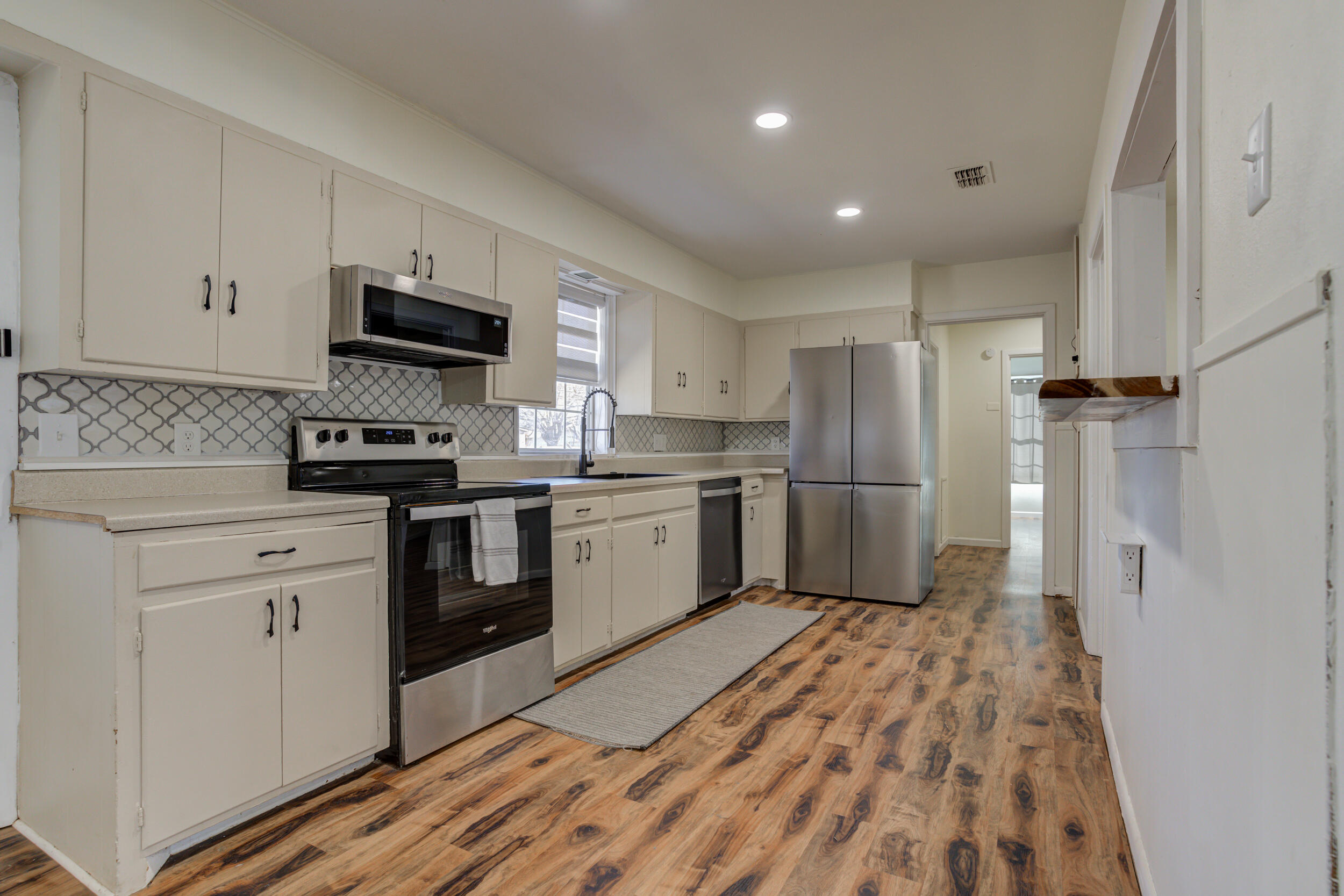 4609 Elgin Avenue Lubbock, TX 79413 - Photo 3 of 46 a kitchen with a refrigerator a sink and a stove