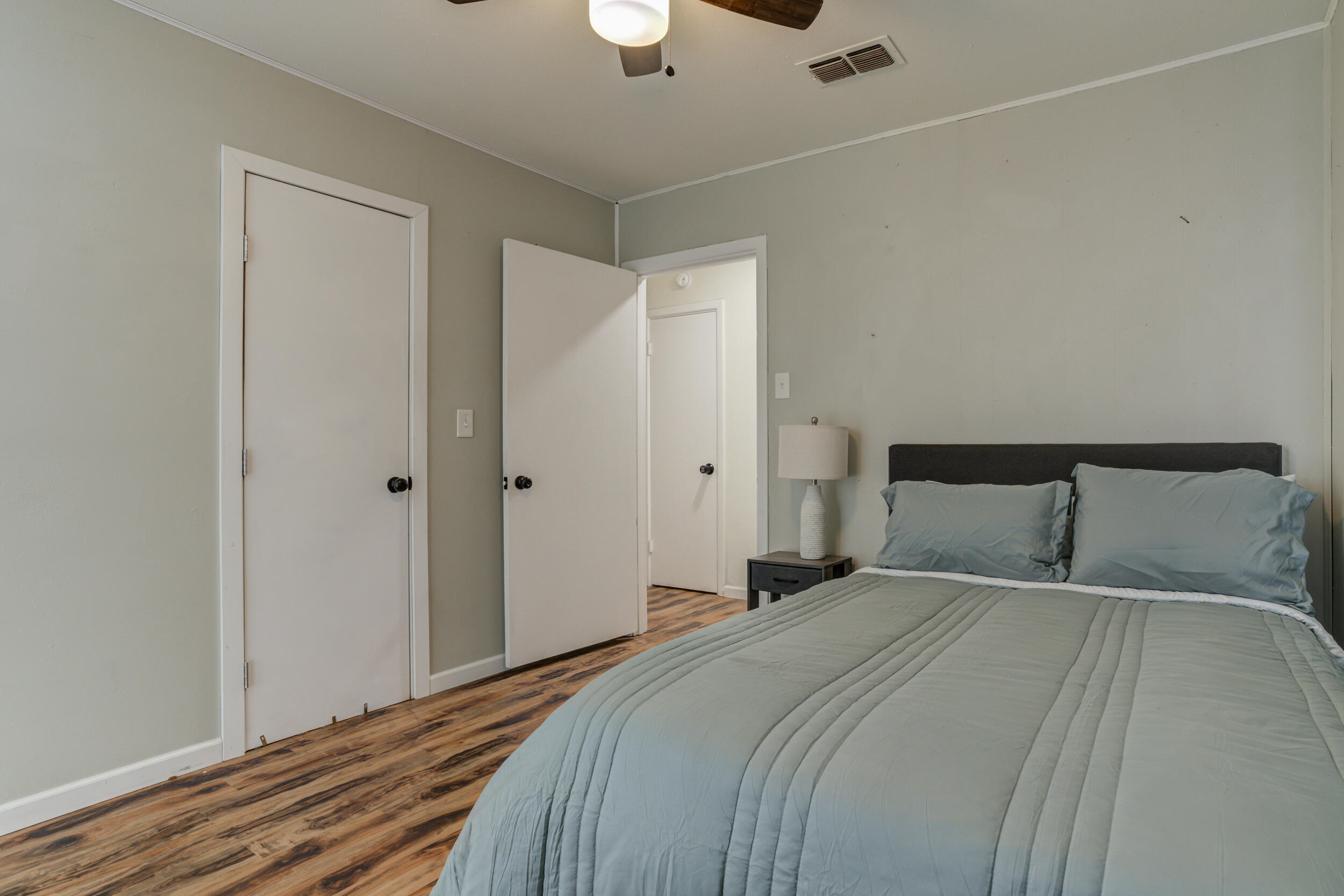 4609 Elgin Avenue Lubbock, TX 79413 - Photo 31 of 46 a bedroom with a large bed and a chandelier fan