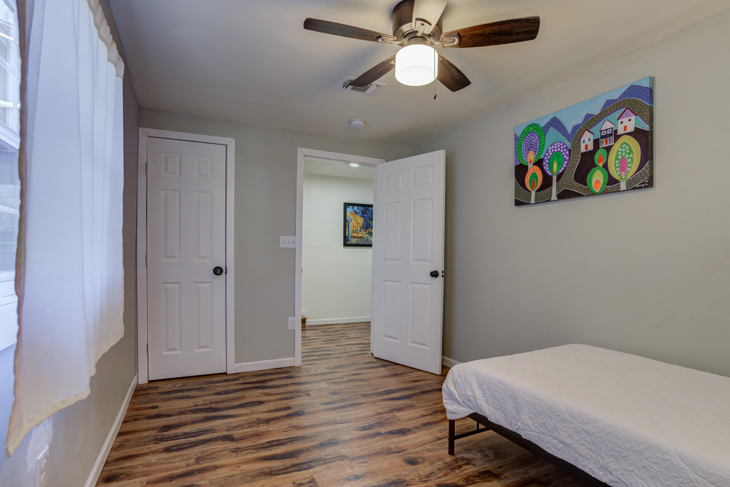 4609 Elgin Avenue Lubbock, TX 79413 - Photo 33 of 46 a bedroom with a bed and wooden floor
