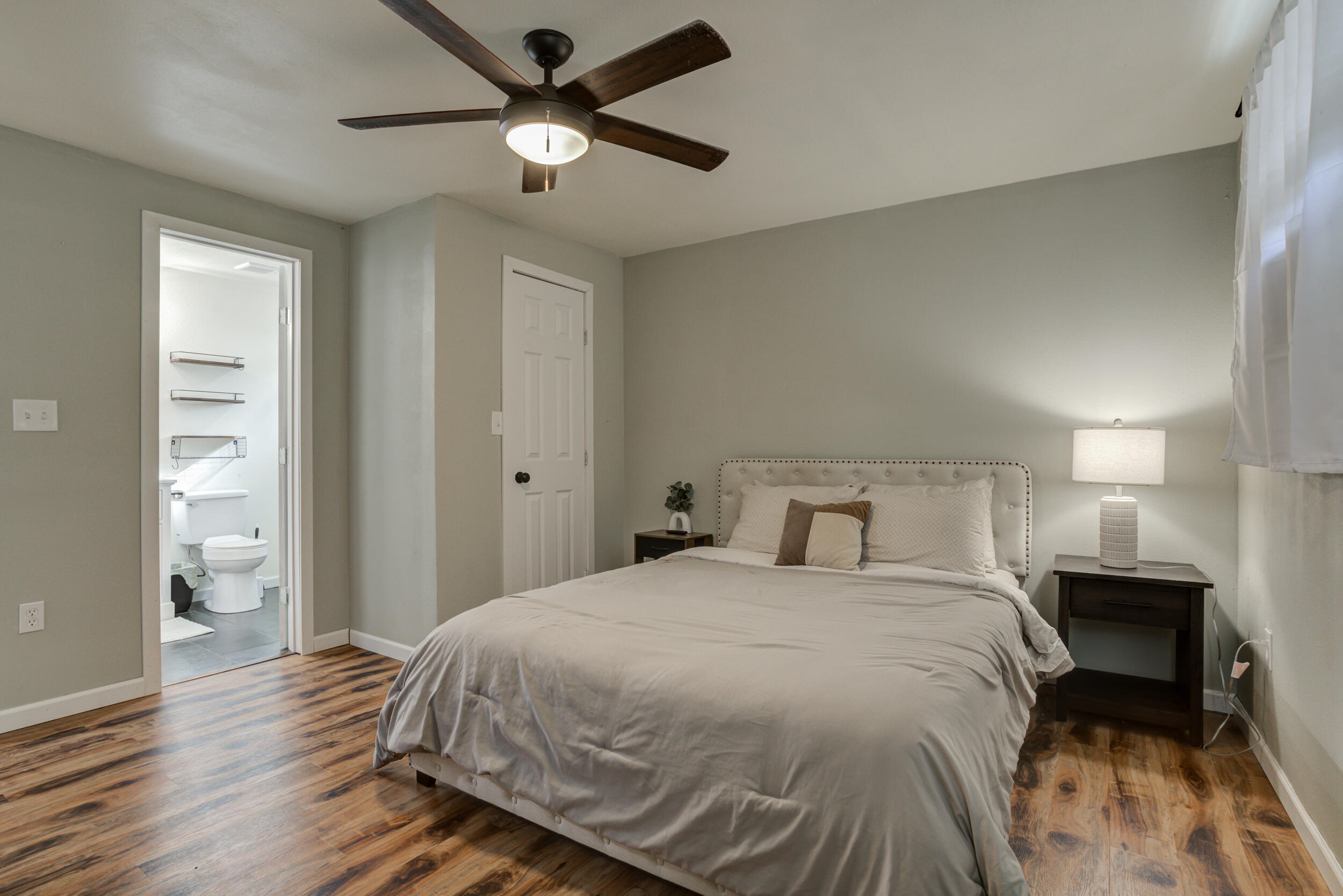 4609 Elgin Avenue Lubbock, TX 79413 - Photo 35 of 46 a bedroom with a bed and a chandelier