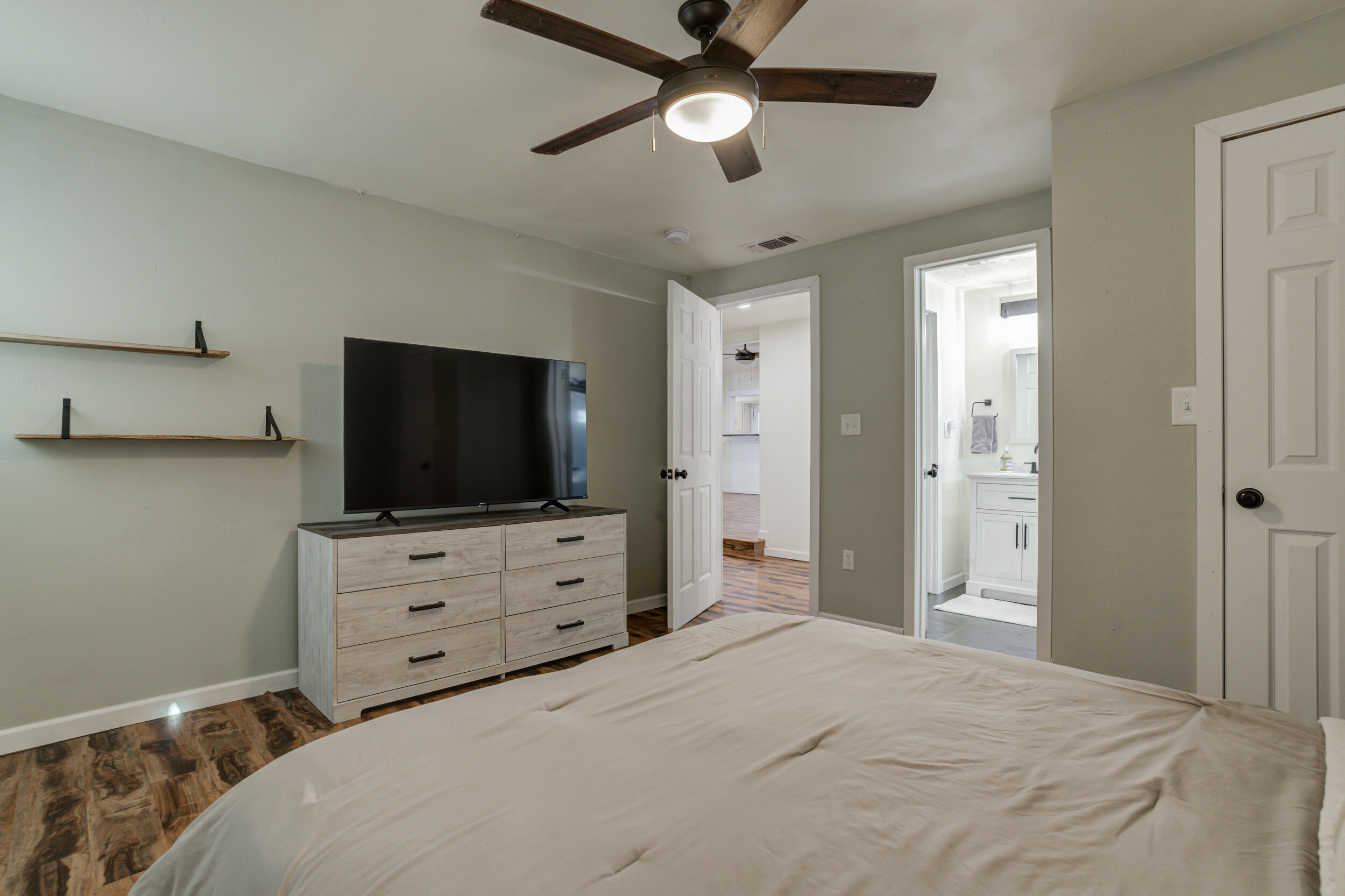 4609 Elgin Avenue Lubbock, TX 79413 - Photo 36 of 46 a bedroom with a bed and a flat tv screen on dresser
