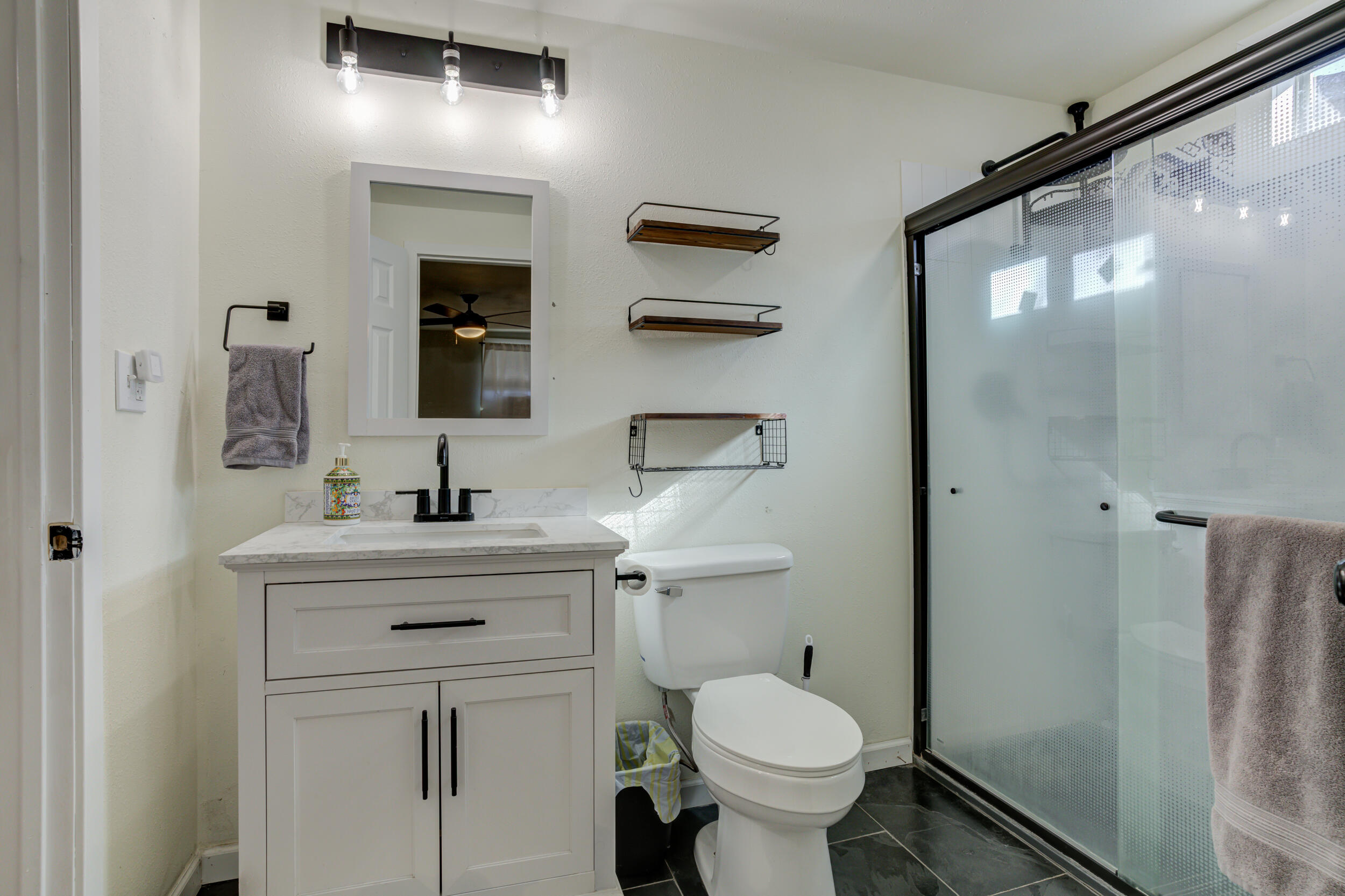 4609 Elgin Avenue Lubbock, TX 79413 - Photo 37 of 46 a bathroom with a toilet sink and mirror
