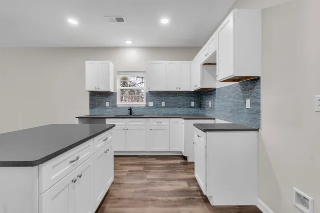 a kitchen with granite countertop white cabinets and white appliances