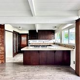 a view of kitchen with kitchen island a stove a refrigerator wooden floor and a large window