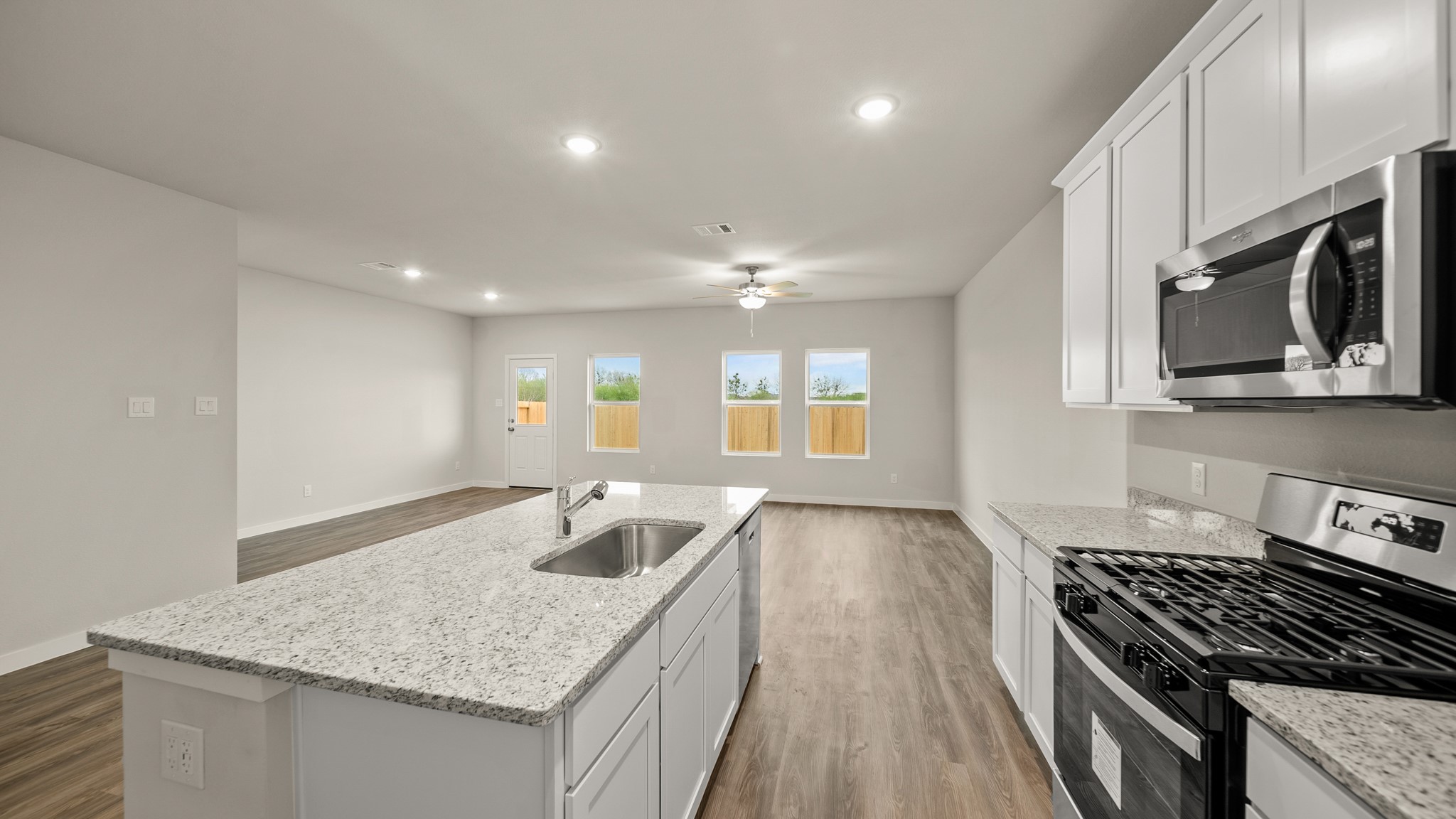 26051 Spiney Thistle Road Katy, TX 77493 - Photo 7 of 22 a kitchen with granite countertop sink stove and cabinets