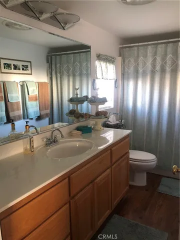 a bathroom with a double vanity sink toilet and a mirror