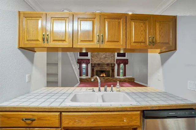 a view of an empty room with wooden floor a fireplace and a window
