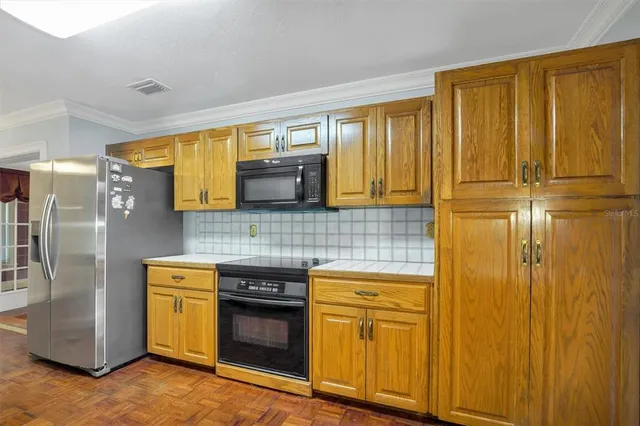 a view of an empty room with a chandelier fan