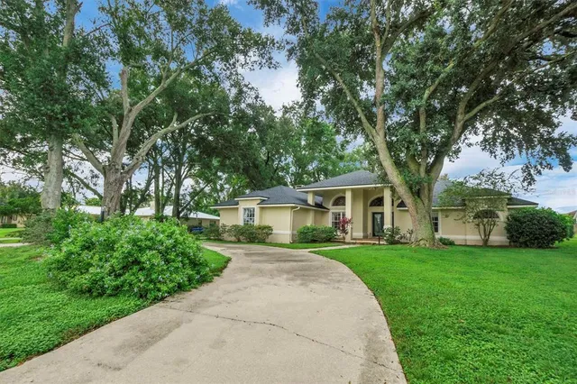 a front view of a house with a yard and trees