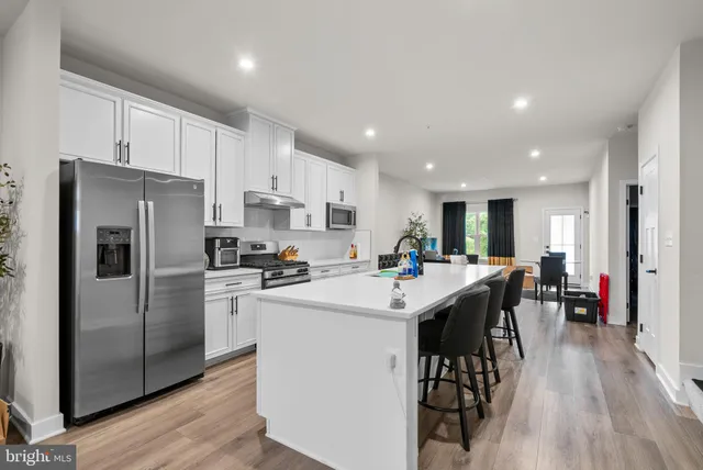a open kitchen with stainless steel appliances granite countertop a lot of counter space and wooden floors