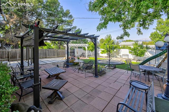 1012 North Chelton Road Colorado Springs, CO 80909 - Photo 15 of 46 Fenced backyard with a pergola, a patio, and a playground
