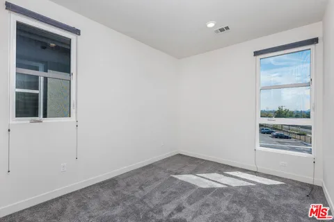 an empty room with entrance and windows