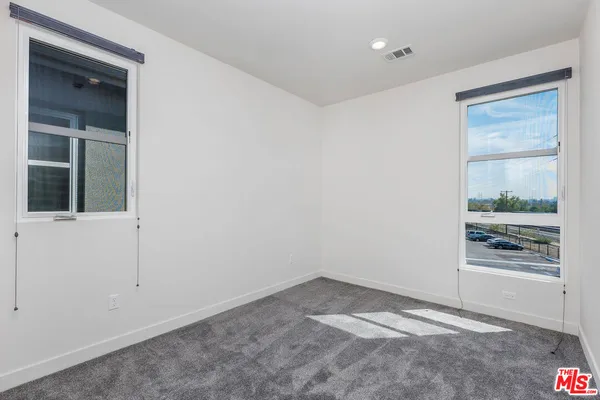 an empty room with entrance and windows