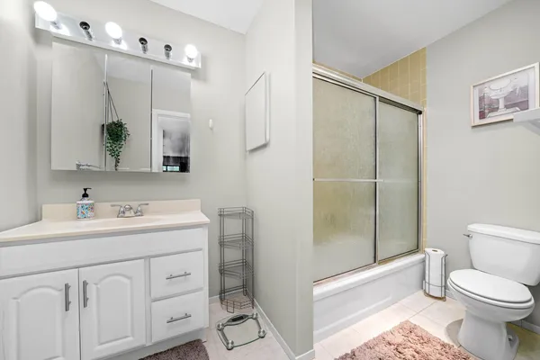 a bathroom with a toilet sink vanity and mirror