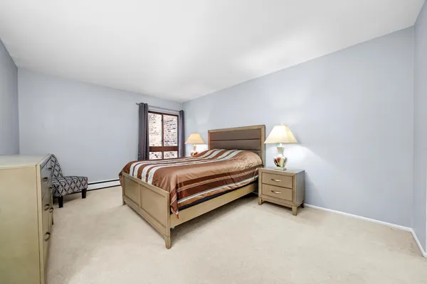 a bedroom with a bed lamp and a window
