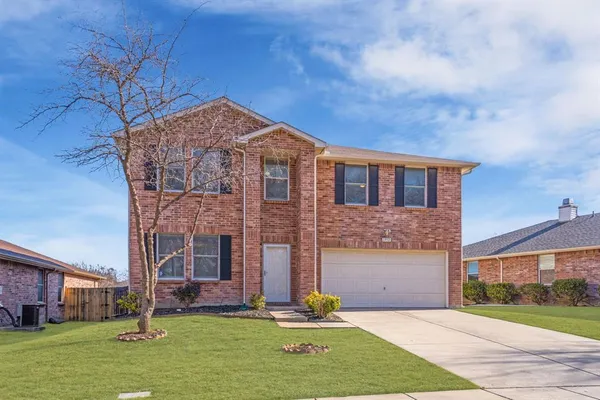 front view of a brick house with a yard
