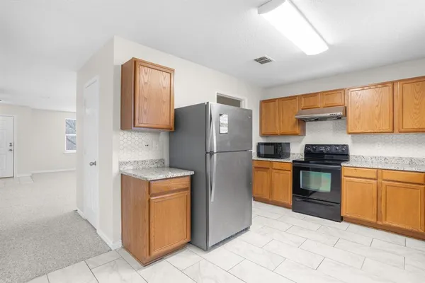 a kitchen with stainless steel appliances granite countertop a refrigerator and a stove