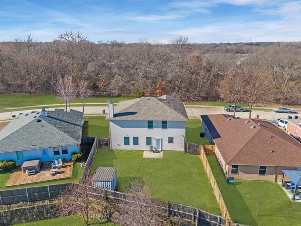 an aerial view of a house with garden space and trees all around