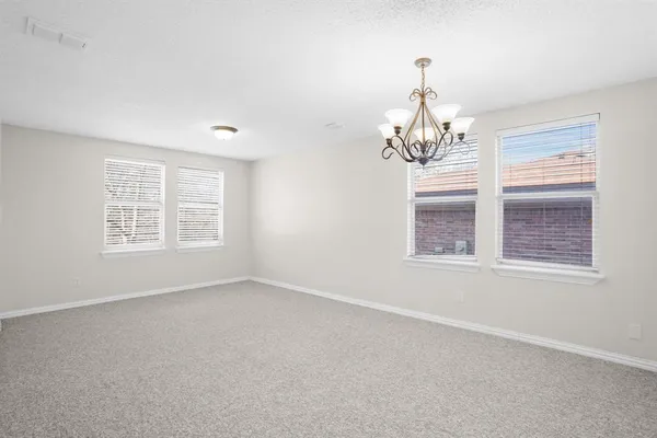 an empty room with windows and chandelier