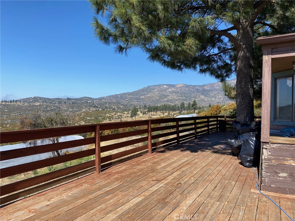 a view of outdoor space with wooden floor and mountain view