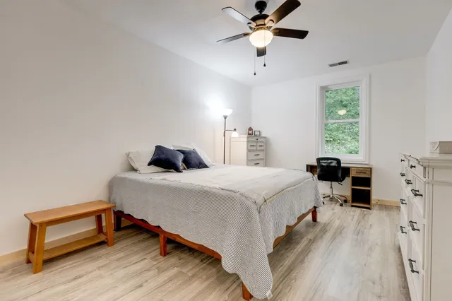 a bedroom with a bed and wooden floor