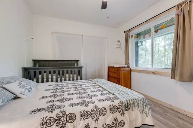 a bed sitting in a bedroom next to a window