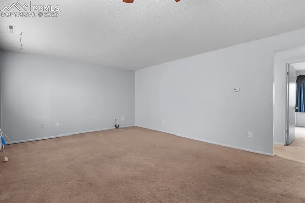 an empty room with a ceiling fan and window