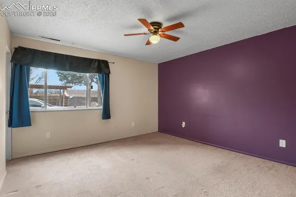 a view of a room with a ceiling fan and a shower