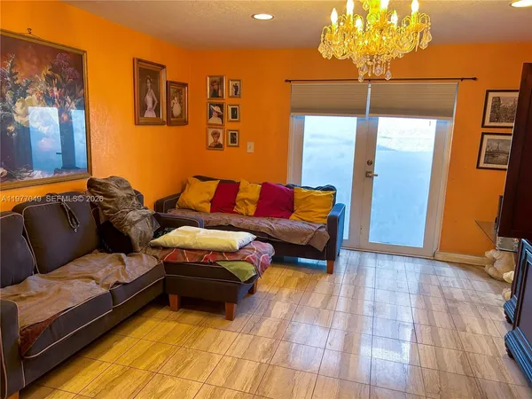a living room with furniture and a chandelier