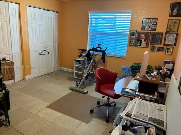 a view of a workspace with furniture and a window