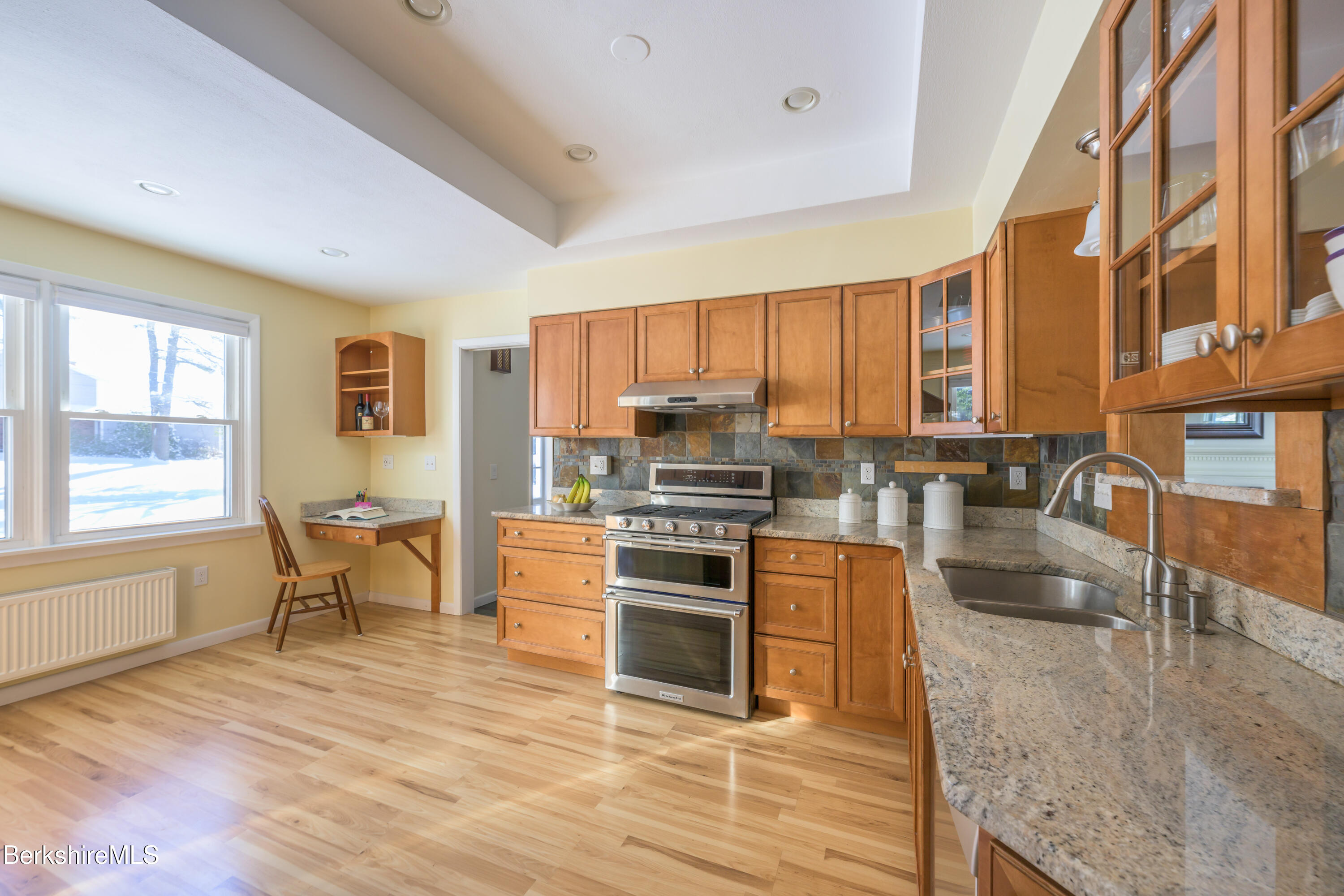 40 Leroi Drive Pittsfield, MA 01201 - Photo 11 of 38 a kitchen with stainless steel appliances granite countertop a stove top oven a sink dishwasher a dining table and chairs with wooden floor