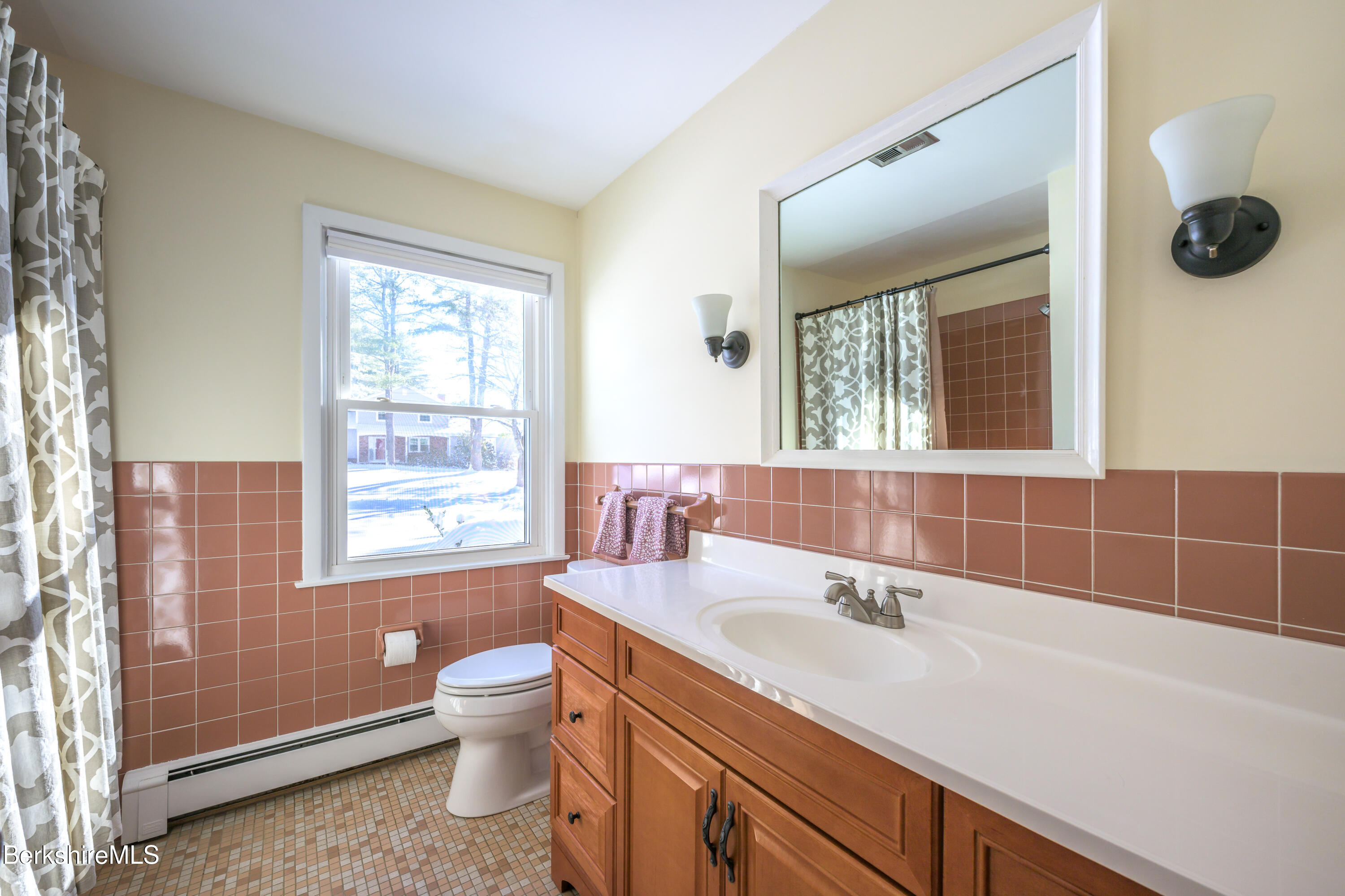 40 Leroi Drive Pittsfield, MA 01201 - Photo 21 of 38 a bathroom with a granite countertop sink a toilet a mirror and a window