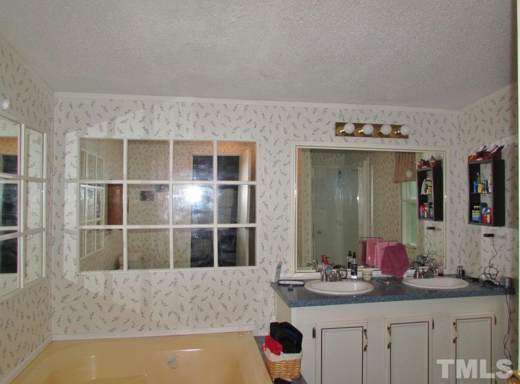 4128 Allensville Road Roxboro, NC 27574 - Photo 11 of 24 a bathroom with a granite countertop sink and a mirror