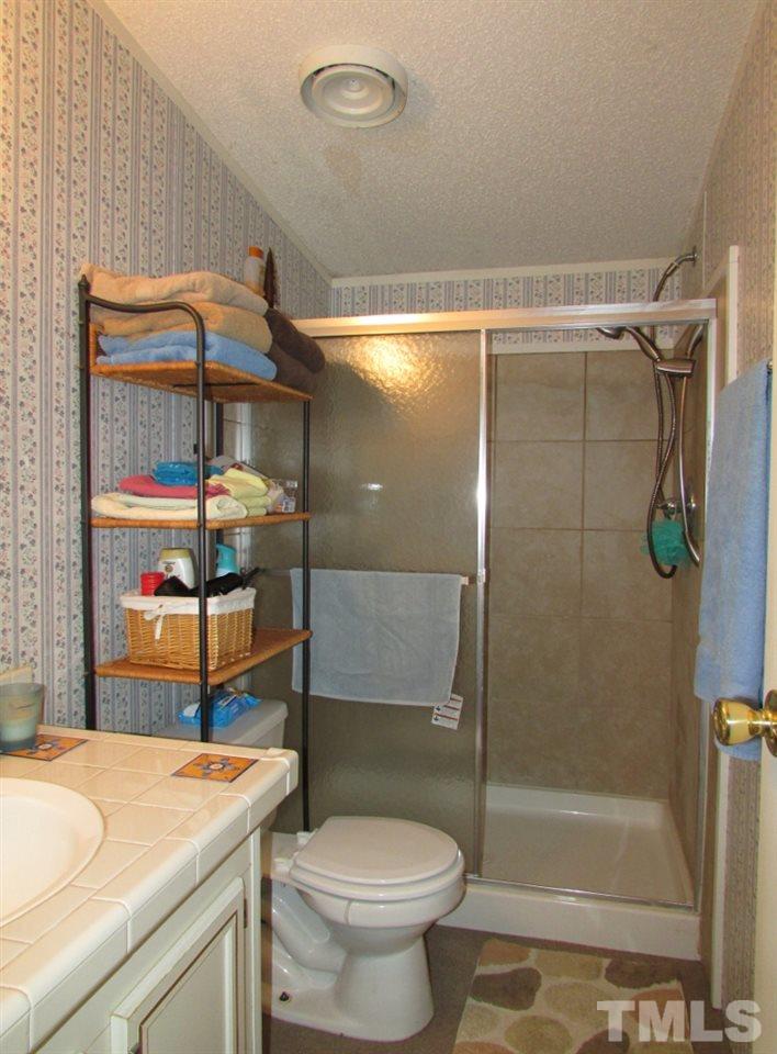 4128 Allensville Road Roxboro, NC 27574 - Photo 13 of 24 a bathroom with a sink toilet and shower
