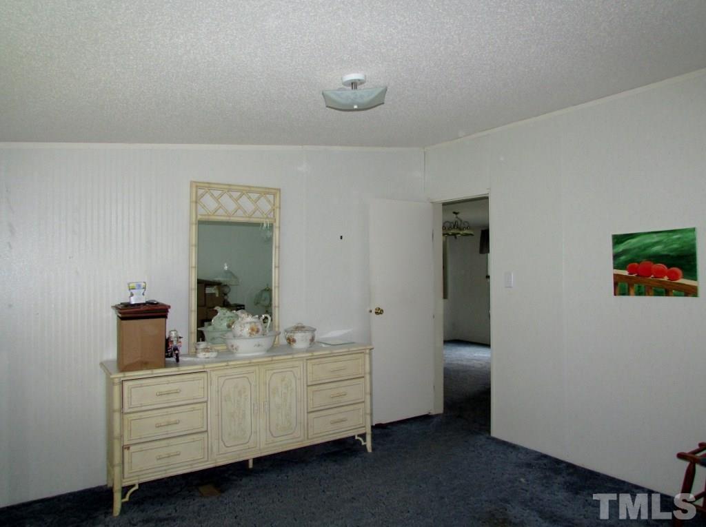 4128 Allensville Road Roxboro, NC 27574 - Photo 14 of 24 a room with a mirror and a dresser