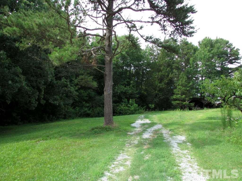 4128 Allensville Road Roxboro, NC 27574 - Photo 23 of 24 a view of a grassy field with trees in the background
