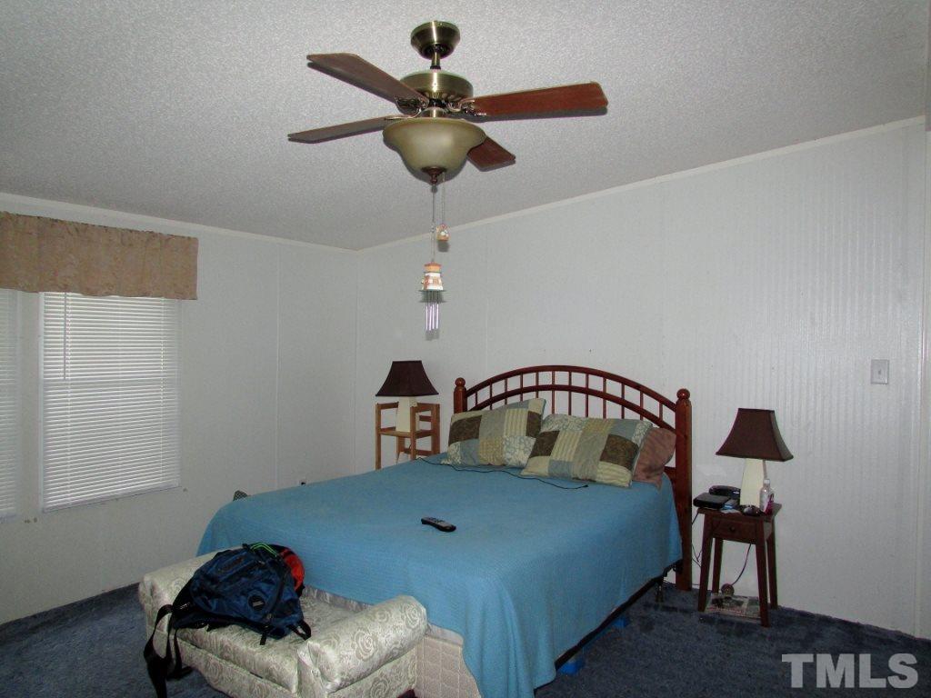 4128 Allensville Road Roxboro, NC 27574 - Photo 9 of 24 a bedroom with a bed and a chandelier