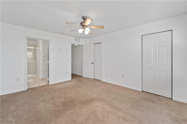 a view of an empty room and chandelier fan