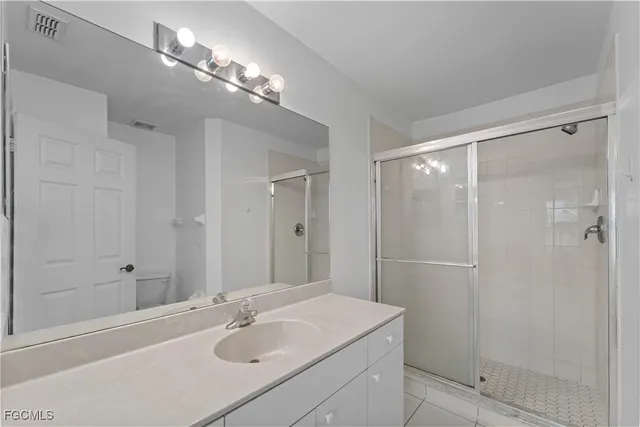 a bathroom with a sink shower and a mirror