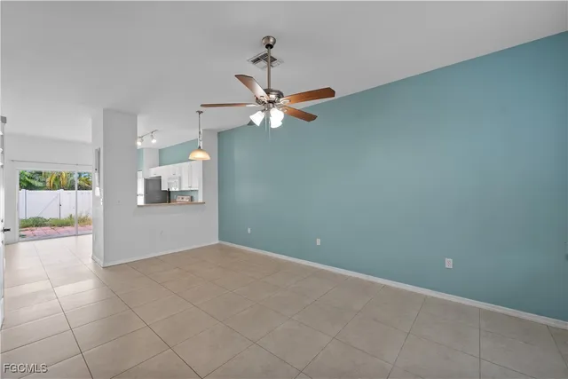 an empty room and chandelier fan