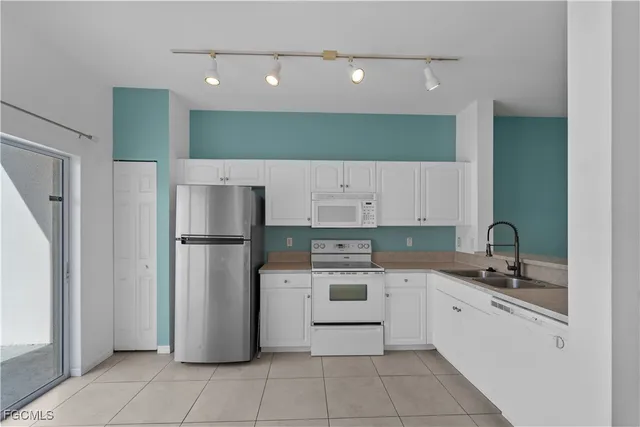 a view of a kitchen with refrigerator and cabinets