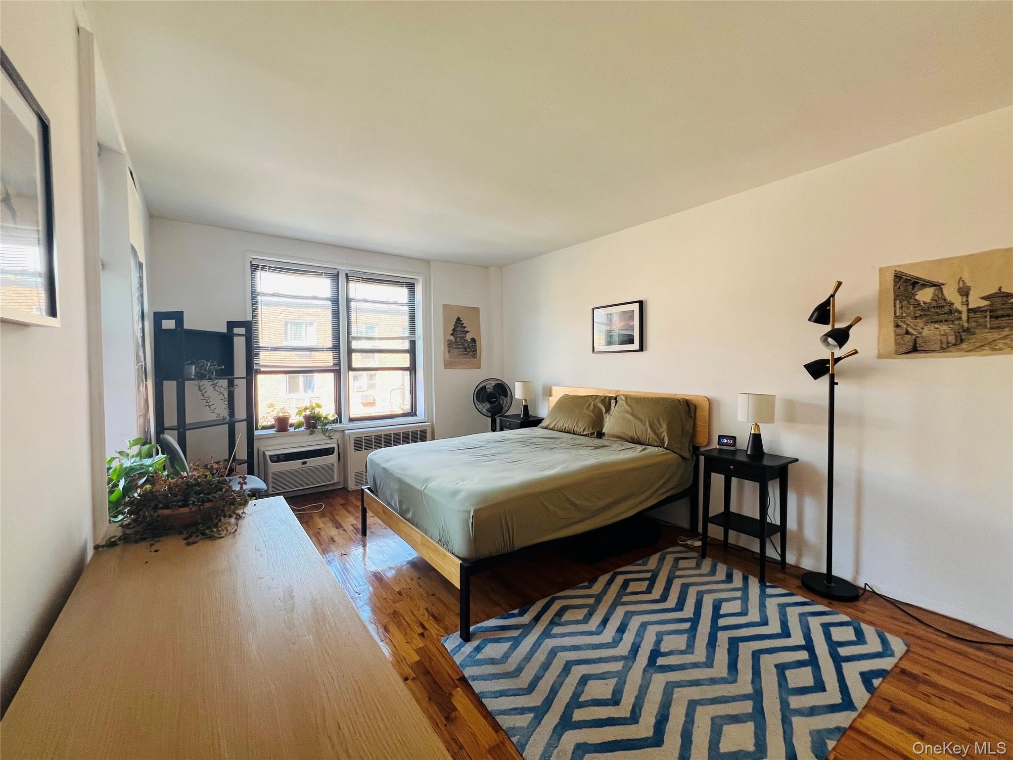 58-03 Calloway Street, Unit 3MM Queens, NY 11368 - Photo 8 of 9 a living room with furniture and a wooden floor