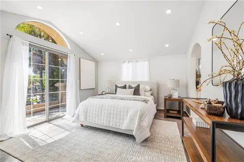 a spacious bedroom with a bed and a lamp