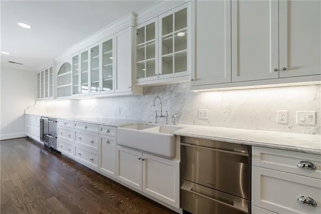 a kitchen with stainless steel appliances granite countertop white cabinets and sink