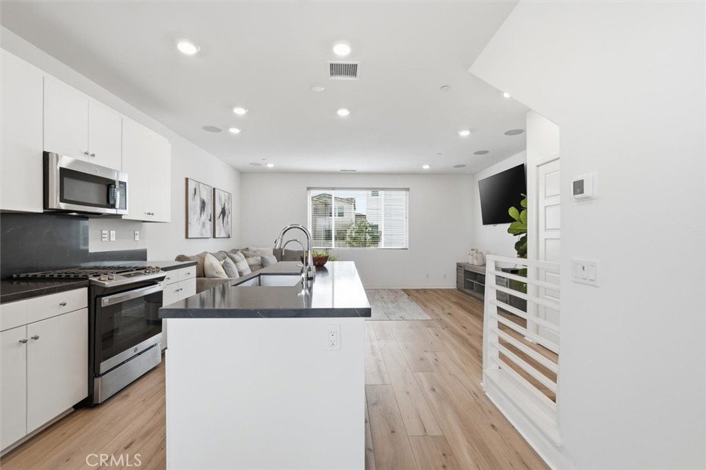 361 Gelding Way Rancho Mission Viejo, CA 92694 - Photo 22 of 59 a large kitchen with stainless steel appliances granite countertop a lot of counter space and wooden floor