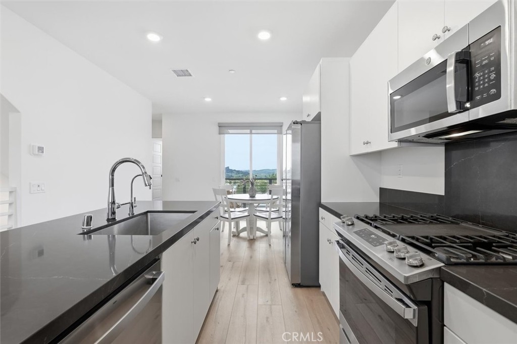 361 Gelding Way Rancho Mission Viejo, CA 92694 - Photo 23 of 59 a kitchen with granite countertop a stove and a sink