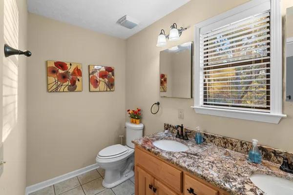 a bathroom with a granite countertop sink mirror vanity and toilet