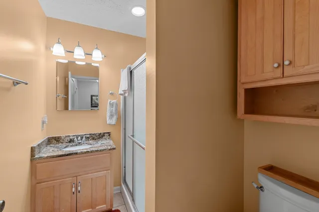 a bathroom with a granite countertop sink and a mirror